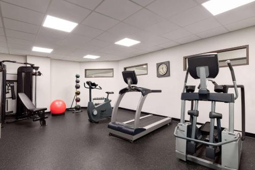 a gym with several tread machines and a clock at Wingate by Wyndham Green Bay in Green Bay