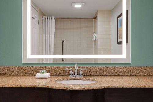 a bathroom with a sink and a mirror at Wingate by Wyndham Green Bay in Green Bay