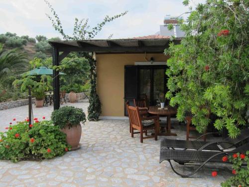 a patio with a table and chairs and plants at Estia Holiday in Gythio
