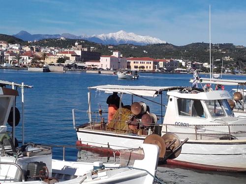 a boat is docked in a harbor with mountains at Estia Holiday in Gythio