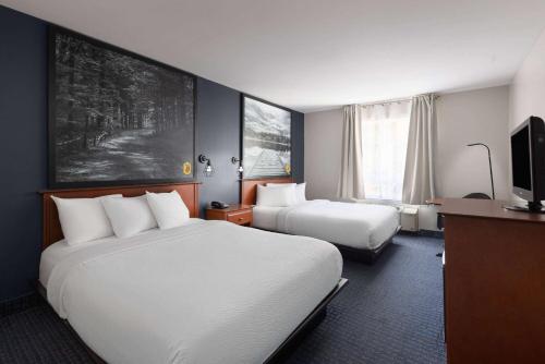 een hotelkamer met twee bedden en een televisie bij Super 8 by Wyndham Sainte Agathe Des Monts in Sainte-Agathe-des-Monts