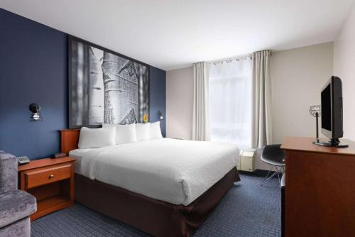 a hotel room with a bed and a television at Super 8 by Wyndham Sainte Agathe Des Monts in Sainte-Agathe-des-Monts