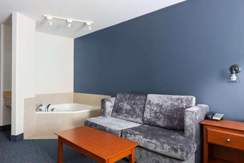 a living room with a couch and a bath tub at Super 8 by Wyndham Sainte Agathe Des Monts in Sainte-Agathe-des-Monts