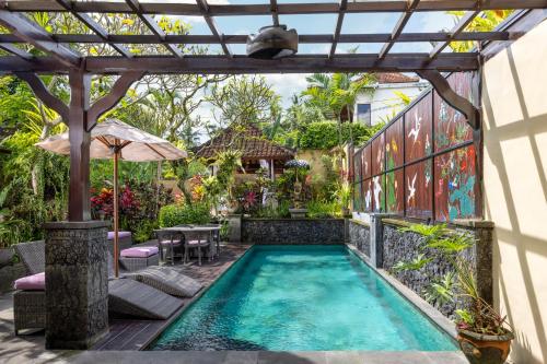 an outdoor swimming pool with a pergola and a swimming pool at Bidadari Private Villas & Retreat in Ubud