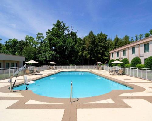 a large swimming pool with chairs and umbrellas at Comfort Inn Monticello in Charlottesville