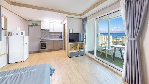 a room with a kitchen and a view of the ocean at Gangneung Glad Pension in Gangneung