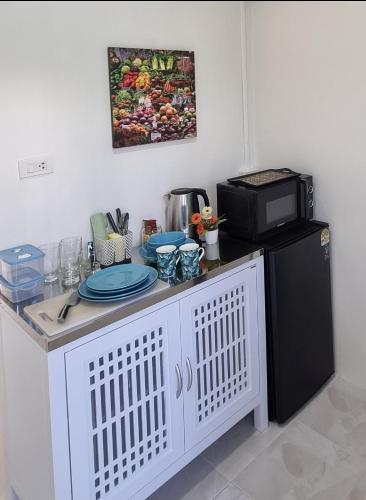 a kitchen with a counter with a microwave and a refrigerator at Songbird Suites - Deluxe King Suite and Scooter in Ao Nang Beach