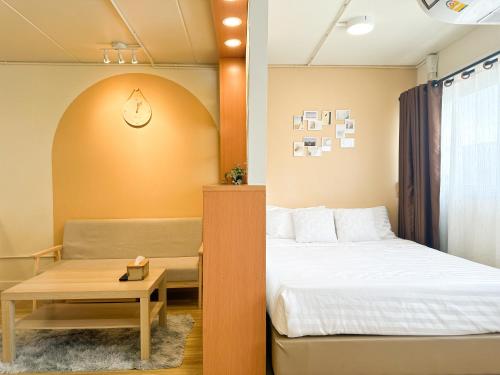 a small room with a bed and a table at Happiness Sleep in Thung Si Kan