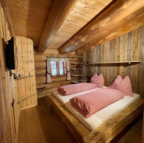 Neustift am AlpenwaldeにあるKulinarik zur Stoa Almの丸太小屋のベッドのある寝室