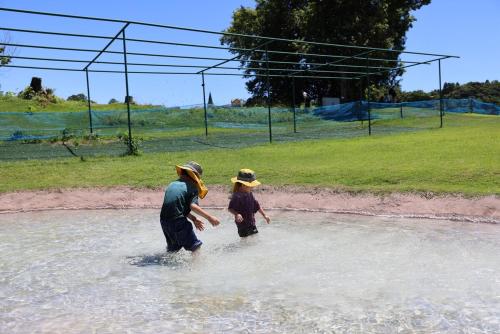 a woman and a child walking in the water at Sakuradai House in Ichihara