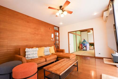 a living room with a couch and a table at Sakuradai House in Ichihara