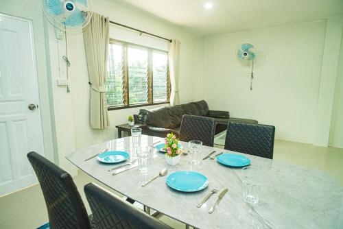 a dining room table with blue plates and chairs at Songbird Suites - Deluxe King Suite and Scooter in Ao Nang Beach