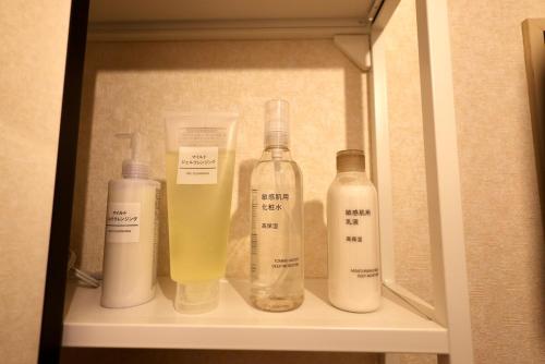a shelf with bottles of soap and a drink at Sakuradai House in Ichihara