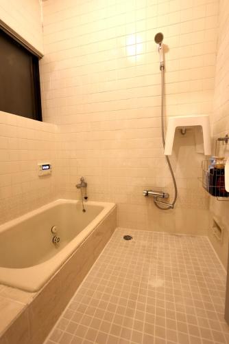 a bathroom with a bath tub and a shower at Sakuradai House in Ichihara