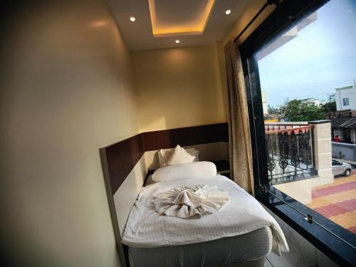 a bed in a room with a large window at Sagar Kuthi in Mandarmoni