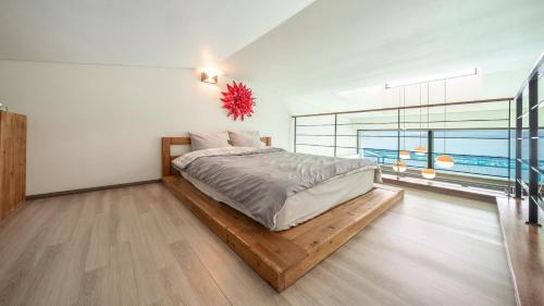 1 dormitorio con 1 cama en una plataforma de madera en Sacheon Bichae Pension, en Sacheon