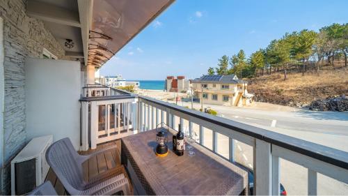a balcony with a table and a view of the ocean at Goseong Araenmaru Pension in Goseong
