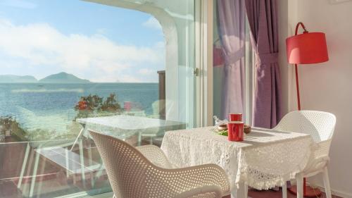 a table and chairs with a view of the ocean at Namhae Opera House Pension in Namhae