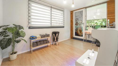 a living room with a plant and a window at Taean Yoyo Kids Poolvilla in Taean