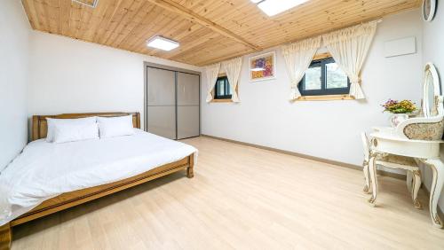 江陵市Gangneung ggabinejip hanok pension的一间卧室配有一张床、一张桌子和一个水槽