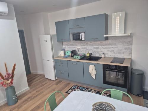 La cuisine est équipée de placards bleus et d'un réfrigérateur blanc. dans l'établissement Trottel a Livia, à Ajaccio