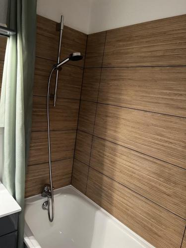 une douche dans une salle de bain avec un mur en bois dans l'établissement Grand Morillon - 104 - Montagne Belle Vue Studio 4, à Morillon