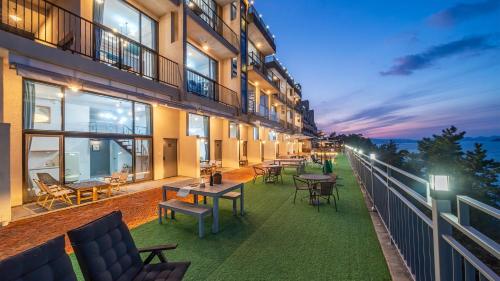 a balcony of a building with tables and chairs at Yeosu dasi bom pension in Yeosu