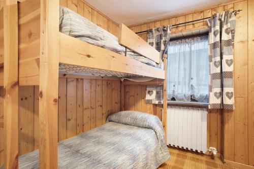 a bedroom with two bunk beds and a window at Casa Chamonin Pila in Gressan