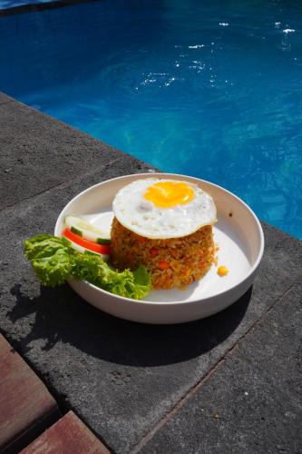 a plate of food with an egg on top at Sadev Resort in Gili Trawangan