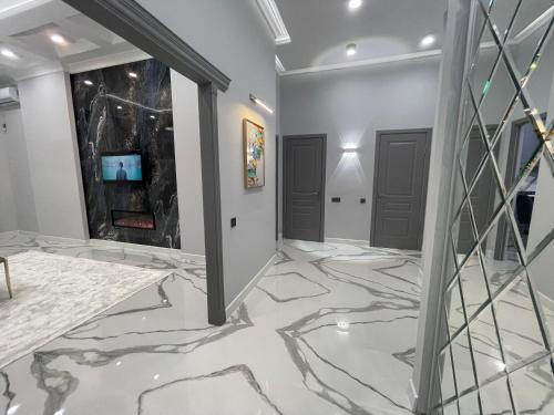 a hallway with marble flooring and two doors at В шикарном районе Атырау возле дворца ЦЕНТР АБАЯ New City от аэропорта 3 минуты in Atyraū