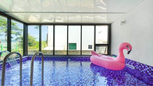 a swimming pool with a pink inflatable flamingo in a house at Gyeongju Blibli Poolvilla in Gyeongju