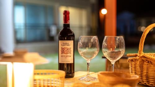 a bottle of wine sitting next to two wine glasses at taean yeonpo haibada pension in Taean