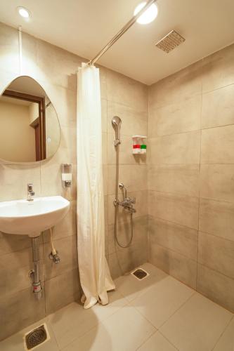 a bathroom with a sink and a shower at MGM Vailankanni in Velānganni