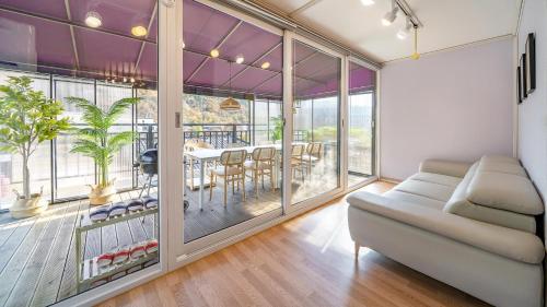 a living room with a couch and a table with chairs at Gapyeong Ddobagi Pet & Spa Glamping in Gapyeong