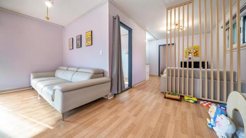 a living room with a couch and a crib at Gapyeong Ddobagi Pet & Spa Glamping in Gapyeong