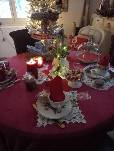 a christmas table with a christmas tree and candles at B&B Luna in Castelvetro di Modena