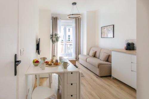un salon blanc avec un canapé et une table dans l'établissement 3P au coeur de Juan les Pins, à Antibes