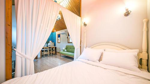 a bedroom with a bed and a dining room at Gapyeong ojeupension in Gapyeong