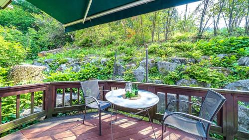 a patio with a table and chairs on a deck at Gapyeong ojeupension in Gapyeong