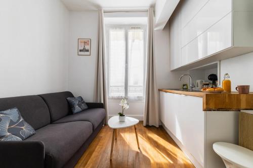 un salon avec un canapé et une cuisine dans l'établissement Studio equipe centre nation - Paris 12 - 2P - FLAT-GUEST, à Paris