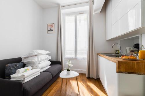 un salon avec un canapé et une cuisine dans l'établissement Studio equipe centre nation - Paris 12 - 2P - FLAT-GUEST, à Paris