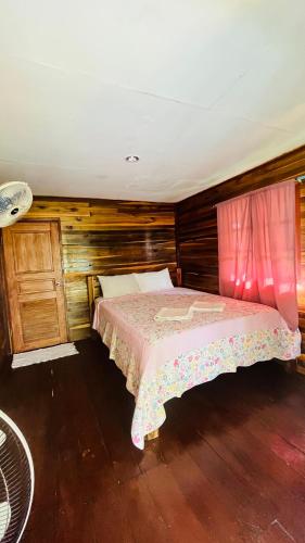 a bedroom with a bed with a pink bedspread at New Klong Khong Garden in Ko Lanta