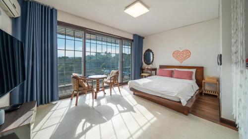 une chambre avec un lit, un bureau et une table dans l'établissement Ganghwado Happyvilly Pension, à Incheon