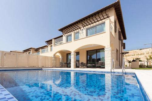 a villa with a swimming pool and a house at Aphrodite Hills Rentals - Elite Villas in Kouklia