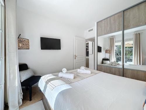 une chambre blanche avec un grand lit et un miroir dans l'établissement Les oliviers St Tropez et plage à pied - 22, à Saint-Tropez