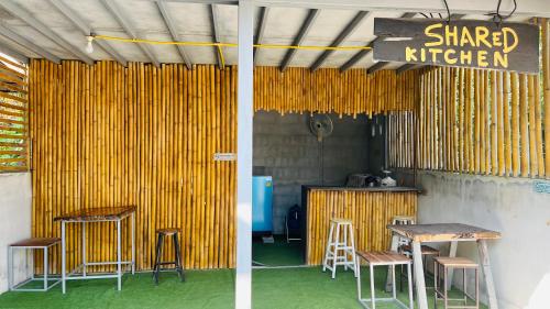 a restaurant with a table and stools and a sign at New Klong Khong Garden in Ko Lanta