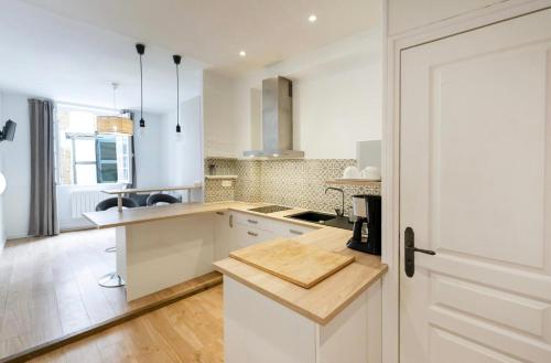 eine Küche mit weißen Schränken und einer Holzarbeitsplatte in der Unterkunft Studio centre historique Bayonne 5 in Bayonne