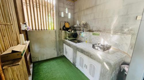 una piccola cucina con un bancone e un pavimento verde di New Klong Khong Garden a Ko Lanta