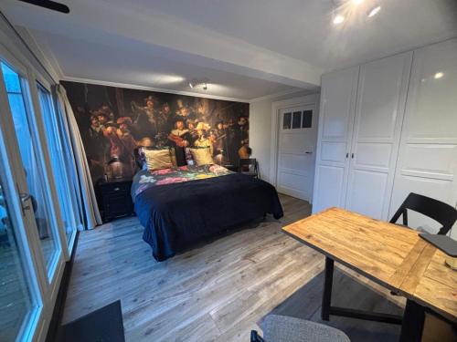 a bedroom with a bed and a painting on the wall at Voorsterstaete former barn, including jacuzzi in Voorst