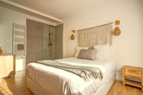 une chambre avec un grand lit et une douche dans l'établissement Le Cottage Bohème Nature Piscine Chauffée Privée du Tarn entre Toulouse et Albi & Les Cottages du Tarn, à Peyrole